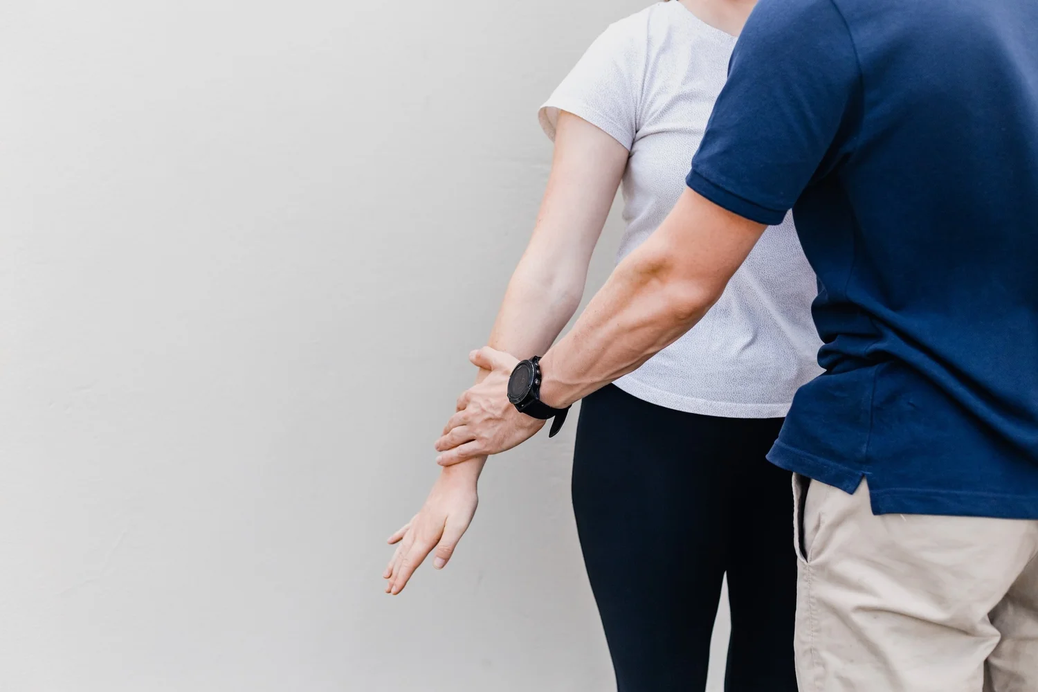 A practitioner’s hand resting on a patient’s outstretched forearm during a muscle test